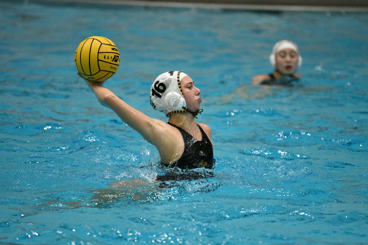 Water polo player in action, preparing to throw ball during a match.