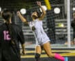 Soccer player in white jersey celebrating a goal on the field at night.