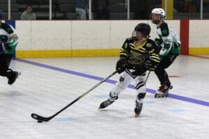 Hockey players in action during a roller hockey match, competing intensely on the rink.