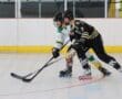 Roller hockey players in action during an intense match on an indoor rink.