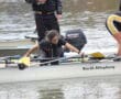 Team at rowing competition aligning oars on water, North Allegheny boat in focus, sunny outdoor setting.