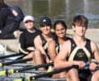 Rowing team smiles on water, ready to race. Team spirit, outdoor sports, teamwork, sunny weather.
