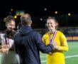 Athletes receiving medals during a nighttime soccer award ceremony on the field.
