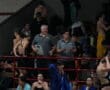 Coaches and swimmers gather poolside at a swim meet, preparing and discussing strategies.