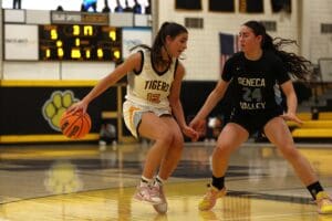 Two basketball players from rival teams in action on the court.