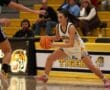 Basketball player dribbles past a defender during a high school game at Tigers arena.