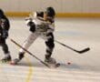 Inline hockey players in intense action on rink, focusing on puck control and teamwork.