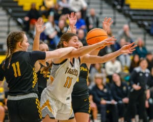 Basketball players in action during a game, competing for ball possession on the court.