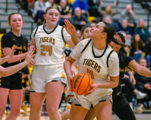 Basketball players in action during a high school game, focusing on teamwork and competition.