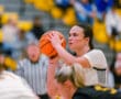 Basketball player focusing on a free throw shot during a game in a gymnasium.
