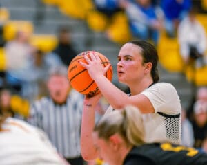 Basketball player focusing on a free throw shot during a game in a gymnasium.