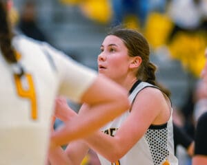 Focused female basketball player prepares to make a move during a game.