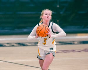 Basketball player in action, wearing number 5 jersey, prepares to pass the ball on the court.