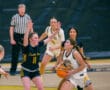 Girls' basketball game, player in white jersey attempts a shot while guarded by opponent in black jersey.