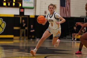 Basketball player in action, dribbling down the court during a game, focused and determined.