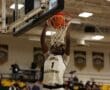Basketball player from North Allegheny scores a slam dunk during a game in a gymnasium.