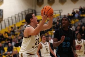 Basketball players in action during a high school game, with one preparing to shoot the ball.