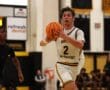 Basketball player from North Allegheny dribbling past a defender during a game in a gymnasium.