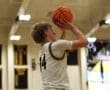 Basketball player in jersey number 14 shooting a basketball in an indoor court during a game.