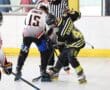 Roller hockey faceoff between players in black and white jerseys on an indoor rink, overseen by a referee.