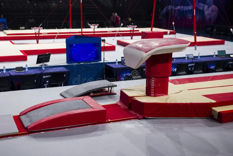 Vaulting table and springboard in a gymnastics arena setup, ready for competition.