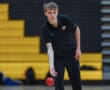 Person in black sportswear playing dodgeball in a gym.