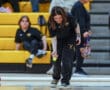 Young athlete playing bocce indoors, focusing on precision, wearing team uniform.