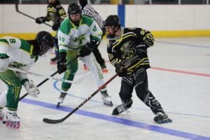 Roller hockey players in intense action on the rink; focused on stick handling and competition.