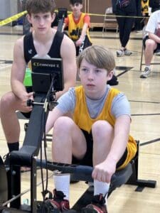 Young athletes competing in an indoor rowing event, focused and determined.