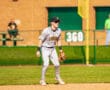 Baseball player in gray uniform poised at second base, ready for action on a sunny day at the baseball field.