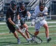 Lacrosse players in action battling for possession on the field, showcasing athleticism and teamwork during a game.