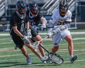 Lacrosse players in action battling for possession on the field, showcasing athleticism and teamwork during a game.