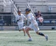 Lacrosse players in action on the field, showcasing teamwork and athleticism during a game.