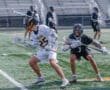 Lacrosse players in action during a game, showcasing teamwork and athleticism on the field.