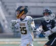 High school lacrosse players compete during a fast-paced game, showcasing skill and teamwork on the field.