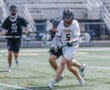Lacrosse players compete fiercely on the field, showcasing athleticism and teamwork in an exciting match.