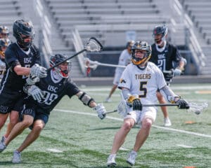 Lacrosse players in action, USC vs. Tigers, showcasing dynamic gameplay on the field.