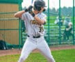 Baseball player in gray uniform prepares to bat, showcasing focus and athleticism on the field.