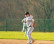 A young baseball player fields a ground ball on a sunny day, showcasing athleticism and focus on the diamond.