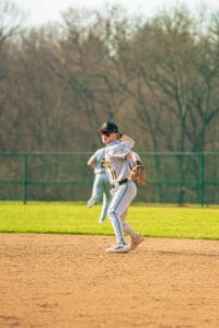 A young baseball player fields a ground ball on a sunny day, showcasing athleticism and focus on the diamond.