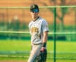 Young baseball player in Tigers uniform stands on the field, ready in the outfield with focus and determination.