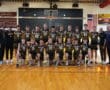 Team photo of Northern Lights volleyball players celebrating their achievement with medals in a gymnasium setting.