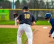 A baseball player wearing jersey number 10 stands at first base, ready for the next play in a game.