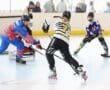 Youth roller hockey players compete in a fast-paced game, showcasing skills in a brightly lit rink.