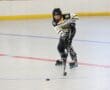 Young roller hockey player in action, skillfully maneuvering on the rink while chasing the puck.