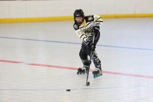 Young roller hockey player in action, skillfully maneuvering on the rink while chasing the puck.
