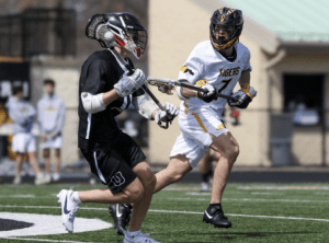 Lacrosse players in action during a game, showcasing athleticism and teamwork on a bright day.