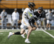 Lacrosse players compete on a field, showcasing athleticism and teamwork during a game.