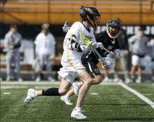 Lacrosse players compete on a field, showcasing athleticism and teamwork during a game.