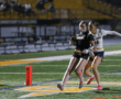 Player runs towards the end zone, pursued by an opponent, showcasing the excitement of a flag football match.